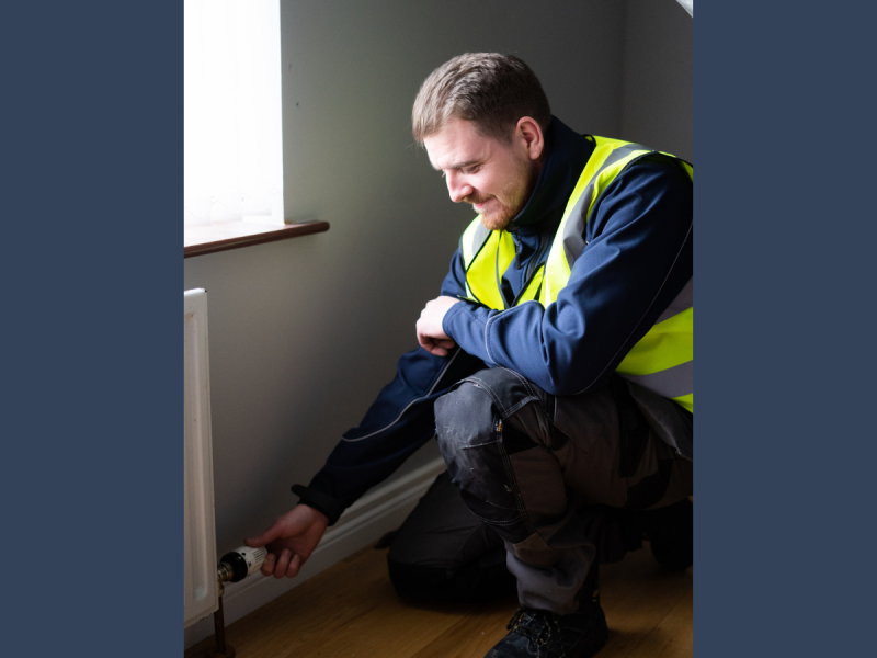 Image of a Greenview staff member working on a radiator for a Social Housing project
